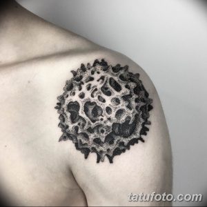 Фото тату на плече: изображение луны, выполненное в технике dotwork (точечная татуировка). Черно-белый рисунок с множеством точек разного размера.