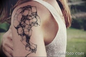 Черно-белая татуировка на плече с изображением абстрактного рисунка, состоящего из сломанных линий и геометрических фигур. Современный и минималистичный стиль.