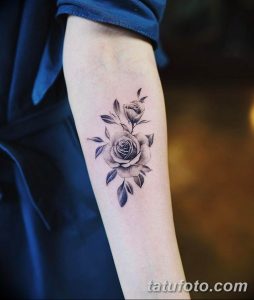 Фото тату: минималистичная татуировка розы, выполненная в технике blackwork, на предплечье. Нежный и элегантный эскиз татуировки для женщин.