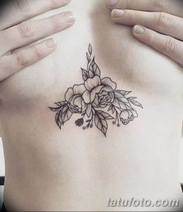 Фото тату: изящный рисунок пионов, выполненный в технике blackwork, расположен на груди. Нежный и романтичный эскиз татуировки для женщин.