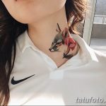 Фото тату: небольшое тату на шее с изображением головы волка и нескольких красных роз, выполненное в акварельной технике.