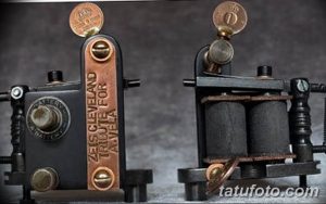 Фотография двух старинных тату-машинок, выполненных в винтажном стиле. Металлические корпуса с деталями и украшениями.