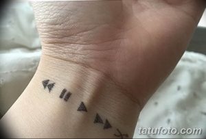 Фото минималистичной татуировки на запястье с изображением кнопок управления плеером.