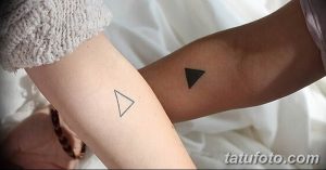 Фото парных тату на запястьях: один треугольник направлен вершиной вверх, другой - вниз, выполнены в черном цвете.