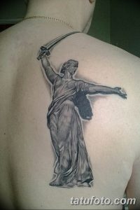 Фото тату Богини Победы с мечом на спине. Крупный рисунок татуировки в стиле реализм, выполненный в серых тонах. Идеально подходит для сильных и уверенных в себе людей.