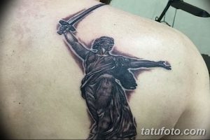 Фото тату Родина-мать на спине, выполненное в черно-серых тонах. Крупный рисунок татуировки с детальной проработкой.