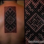 Фото татуировки на спине, выполненной в стиле трайбл. Сложный геометрический узор из черных линий, напоминающий лабиринт.