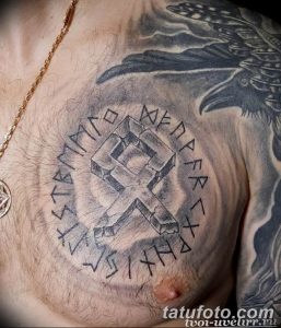 Фото тату: изображение коловрата, окруженного рунами, на груди. Детализированная проработка символов и узоров.