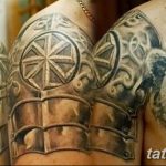 Фото тату: изображение славянской брони на плече и груди, дополненное реалистичной головой медведя. Детализированные пластины и кельтские узоры.