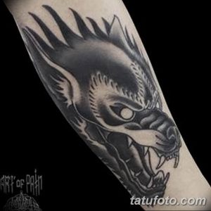 Фото тату на руке с изображением головы дракона в стиле blackwork. Детализированный рисунок татуировки с острыми линиями и выразительным взглядом.
