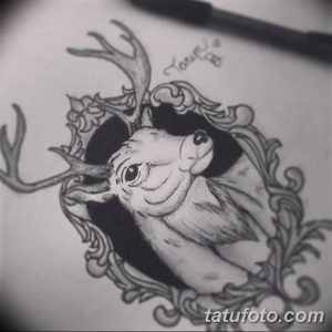 Эскиз татуировки головы оленя, окруженной витиеватыми барочными узорами, выполненный в технике графики с использованием теней.