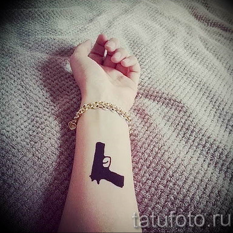 Тату пистолет на руке у девушки