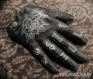Фото тату: традиционный рисунок розы, игральных карт и надписей, выполненный на кожаной перчатке. Яркий и запоминающийся дизайн.
