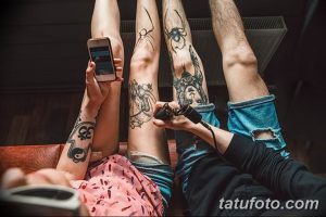 Фото процесса нанесения татуировки: мастер делает тату на ногах клиентам, один из которых смотрит в телефон. Видны эскизы и инструменты.