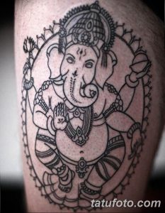 Фото тату Ганеши на руке, выполненное в технике blackwork. Детализированный рисунок татуировки с множеством мелких элементов и узоров.