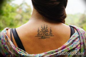 Фото тату Сак Янт на спине девушки, выполненное в традиционном тайском стиле черными чернилами. Изображены геометрические фигуры и тайские письмена.