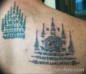 Фото тату: черно-серые геометрические узоры и символы на спине мужчины. Традиционная тайская татуировка, выполненная в строгом стиле.