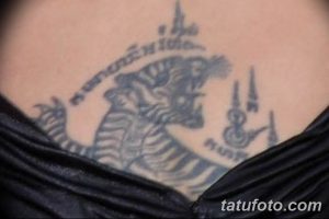 Фото тайской татуировки с изображением головы мифического существа, возможно, дракона или наги. Черные линии и традиционные узоры создают загадочный и мощный образ.