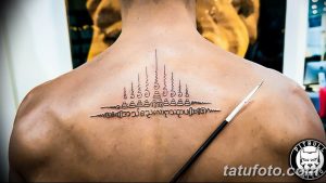 Фото традиционной тайской татуировки (сак янт) на спине мужчины. Черные линии и символы создают мощный и мистический образ. Идеальный эскиз для тех, кто интересуется восточной культурой.