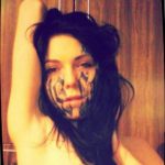 Фото татуировки в виде маски на лице девушки. Черно-белое изображение с элементами готики и мистики.