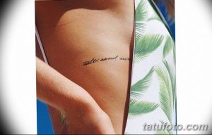 Фото тату: минималистичная надпись "salt, sand, sun" черным шрифтом на боку тела, выполненная в стиле леттеринг.