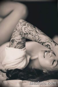 Фото татуировки на руке, выполненной в стиле blackwork. Сложный узор из растительных элементов и геометрических фигур покрывает всю поверхность руки.