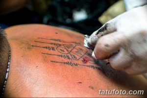 Фото традиционной тайской татуировки (сак янт) на спине. Черные линии и символы создают мощный и мистический образ. Идеальный эскиз для тех, кто интересуется восточной культурой.