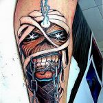 Фото татуировки на руке с изображением Эдди, талисмана группы Iron Maiden. Детализированный черно-серый рисунок с элементами киберпанка.