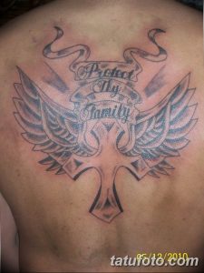 Фотография татуировки на спине с изображением крыльев ангела и надписи "Protect My Family". Черно-серый рисунок татуировки в стиле графика.