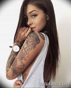 Фотография девушки с рукавом татуировок на руке. На татуировке изображены цветы, животные, геометрические узоры и другие элементы в различных стилях.