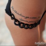 Фотография татуировки на бедре девушки. Это длинная надпись, выполненная изящным шрифтом, обвивающая бедро. Рядом с надписью изображена цепочка.