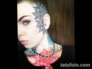 Фотография девушки с необычной татуировкой на лице и шее. На лице изображен геометрический узор, а на шее – яркие цветы и абстрактные элементы.