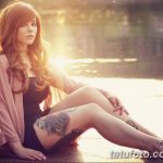 Фотография девушки с татуировкой в виде цветка на ноге, выполненной в акварельном стиле.