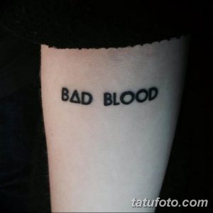 Фото тату: черная надпись 'BAD BLOOD' на предплечье. Стильная и лаконичная татуировка с использованием простого шрифта.