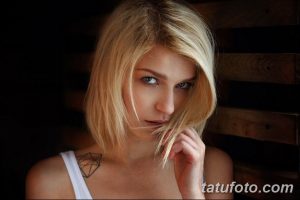Фото минималистичной татуировки в виде геометрической фигуры на ключице девушки. Черный контур, четкие линии, лаконичный дизайн.