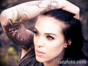 Фотография руки девушки, полностью покрытой татуировками. Татуировки выполнены в ярких цветах и представляют собой сложную композицию из различных элементов, включая цветы, животных и узоры.