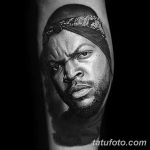 Фото тату: черно-серое реалистичное портретное тату рэпера Ice Cube на руке, выполненное с высокой детализацией и изображением банданы.