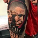 Фото тату с портретом V из фильма 'V значит Вендетта' на руке. Реалистичный рисунок с использованием черных и красных оттенков.