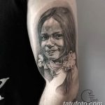 Фото тату портрета девочки с цветами на руке. Черно-белая татуировка в стиле реализм с детальной проработкой лица и волос.
