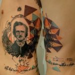 Фото тату с изображением Эдгара Аллана По в окружении геометрических фигур и цитаты из его произведений на боку.