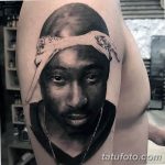 Фото тату: реалистичный портрет 2Pac с банданой на голове на предплечье. Черно-белая татуировка с высокой детализацией и реалистичным изображением лица.