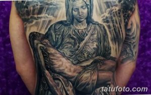 Фото тату: масштабная татуировка на спине, изображающая Пьету Микеланджело. Черно-белая татуировка с высокой детализацией и реалистичным изображением фигур.