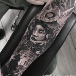 Фото тату портрета самурая в доспехах на руке. Детализированный черно-серый рисунок с элементами японской культуры.