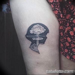 Фото тату на руке, изображающее профиль лица, внутри которого находится мозг и взрыв. Рисунок татуировки выполнен в черно-белой гамме.