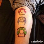 Фото тату на ноге с изображением трех грибов Super Mario разных цветов. Яркий и игривый рисунок татуировки в стиле пиксель-арт.