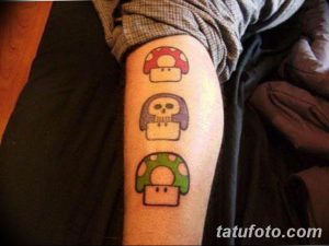 Фото тату на ноге с изображением трех грибов Super Mario разных цветов. Яркий и игривый рисунок татуировки в стиле пиксель-арт.