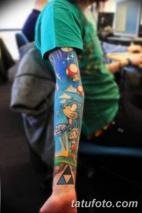Фото татуировки на руке с персонажами и элементами из игры Super Mario. Рисунок выполнен в ярких, насыщенных цветах с использованием техник штриховки и контурной обводки.