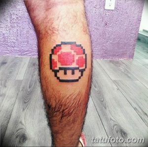 Фотография пиксельной татуировки на ноге с изображением гриба из игры Super Mario. Простой и стильный рисунок татуировки в стиле 8-bit.
