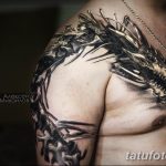 Фото тату: детализированная татуировка дракона, охватывающая плечо и часть груди, выполненная в реалистичном стиле.