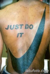 Фото тату на спине: надпись 'Just Do It' и логотип Nike, выполненное в синем цвете.